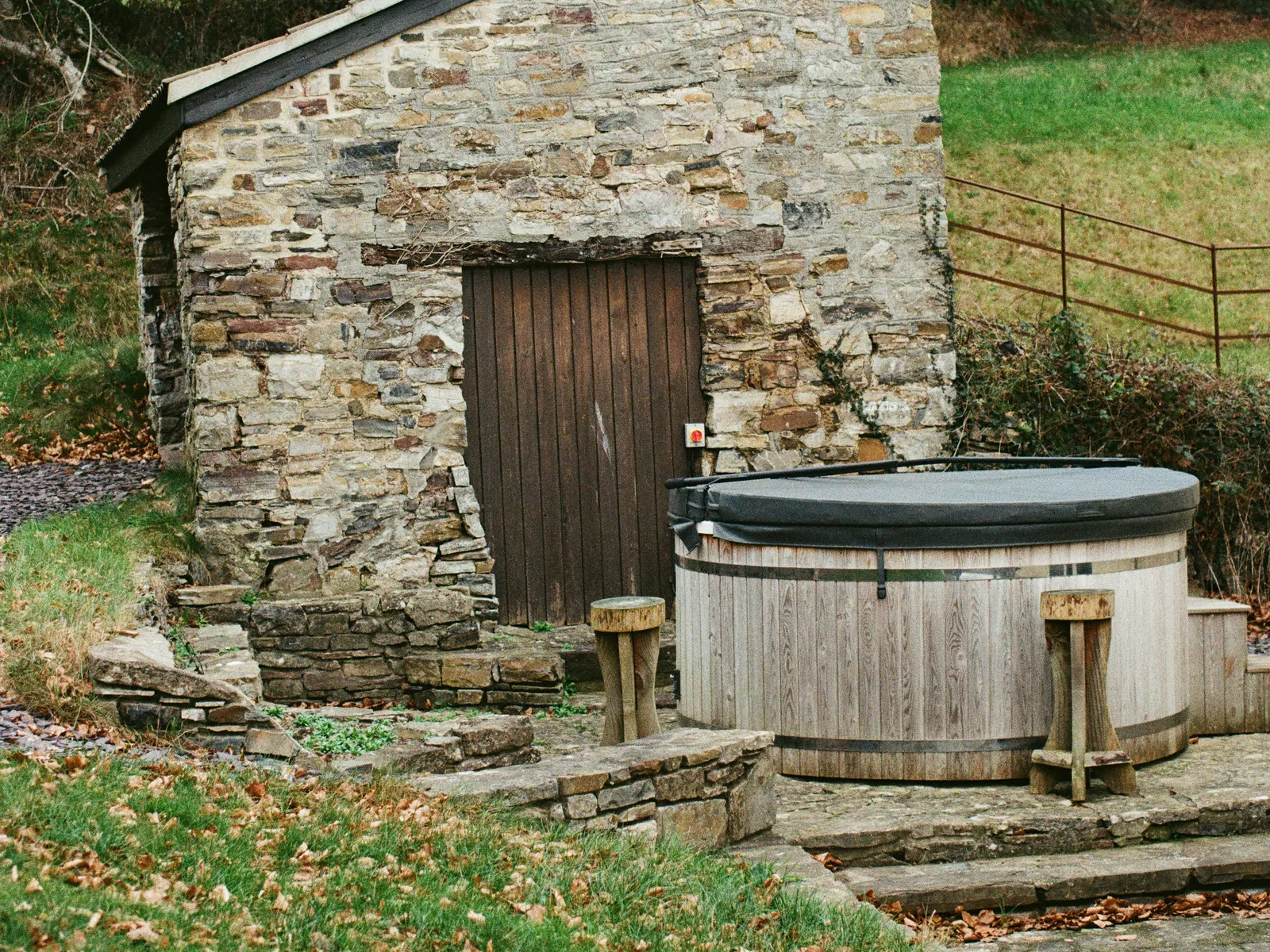 Bain nordique en bois devant un abri en pierre