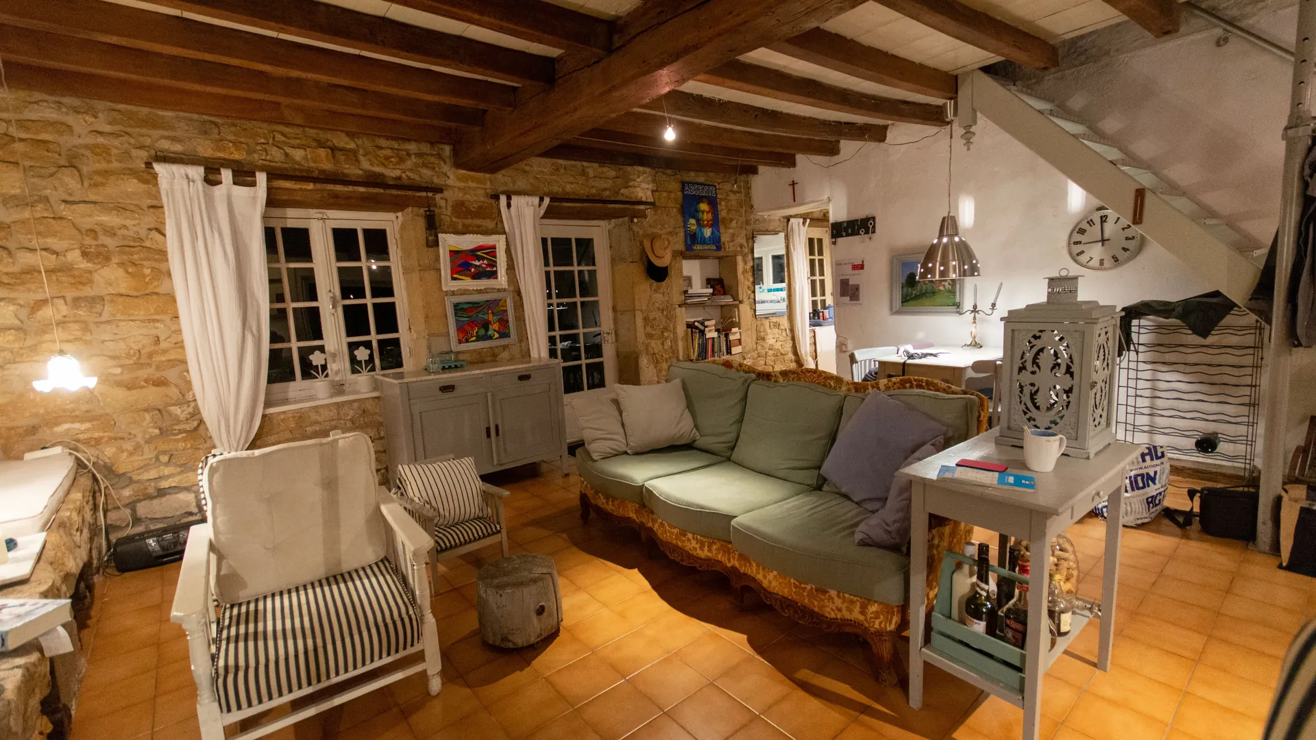 Salle commune avec poutres, tomettes et canapé